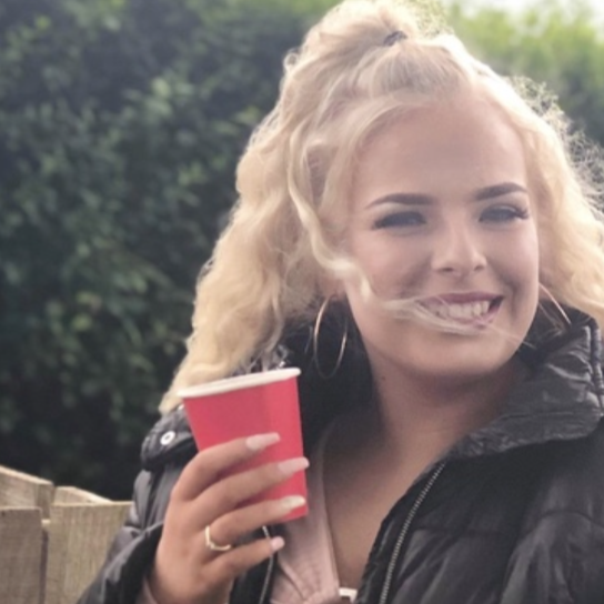 Charlotte Donaldson smiling at the camera, holding a red cup