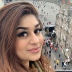 Elise Sajed smiling at the camera, standing above a street scene