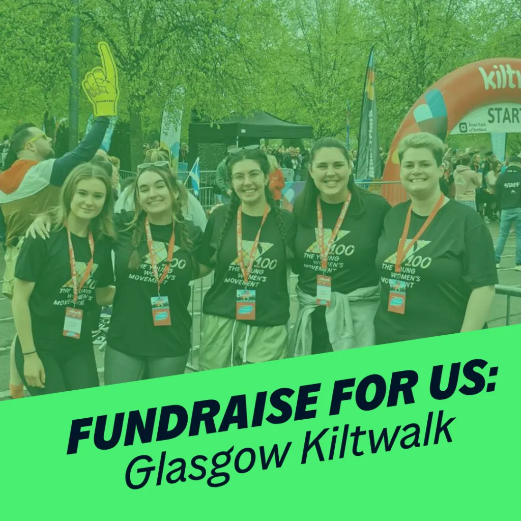 Five women smile at the camera. behind them is the kiltwalk finish line. Green banner reads 