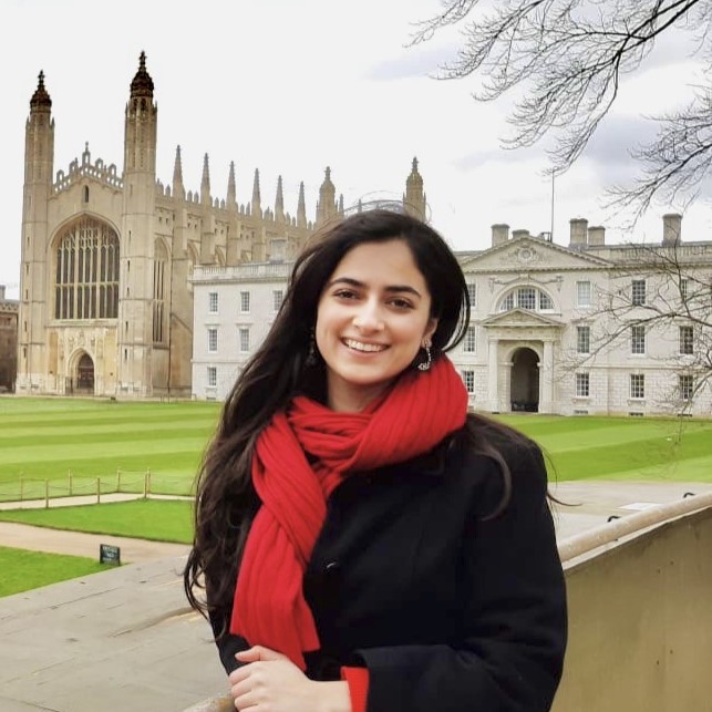 Mashal Aamir smiling at the camera in front of impressive architecture