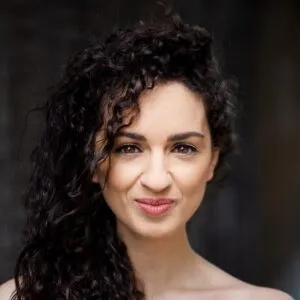 Mia looking into the camera against a dark background