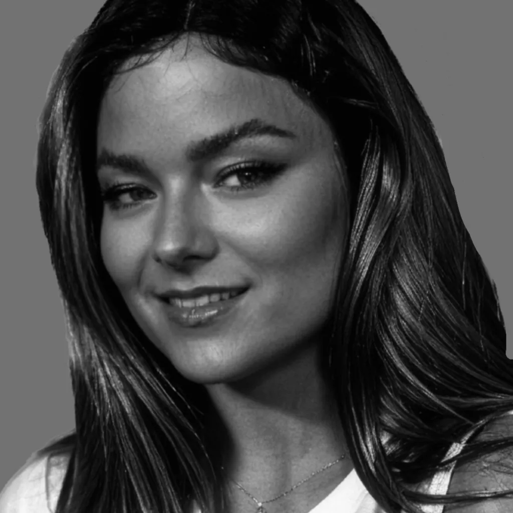 Black and white photo of Rebekah who has long hair and is smiling at the camera.