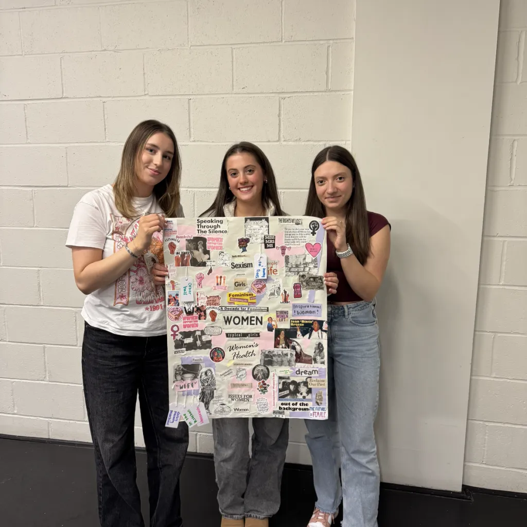 Three young women with dark hair and pale skin are holding up a feminist collage.