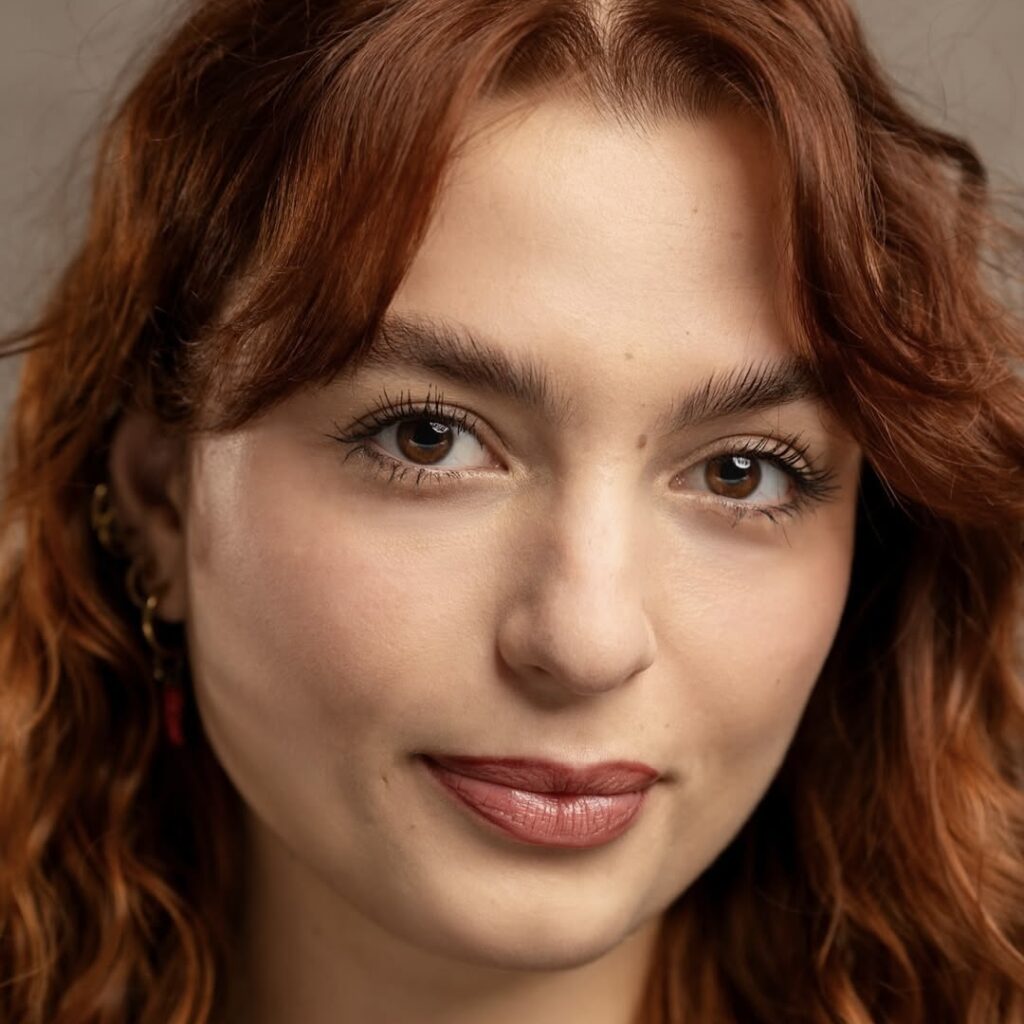 Gaia has pale skin and curly red hair.