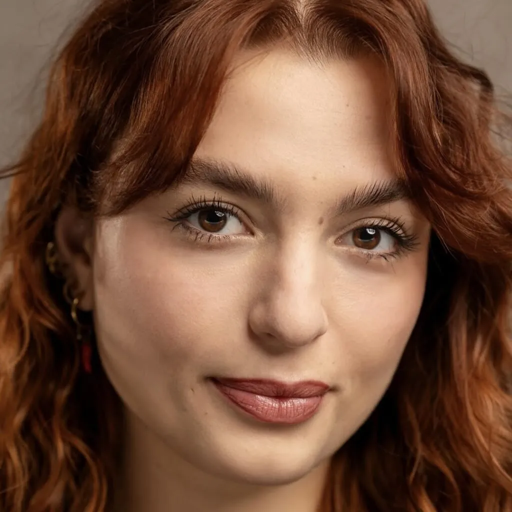 Gaia has pale skin and curly red hair.