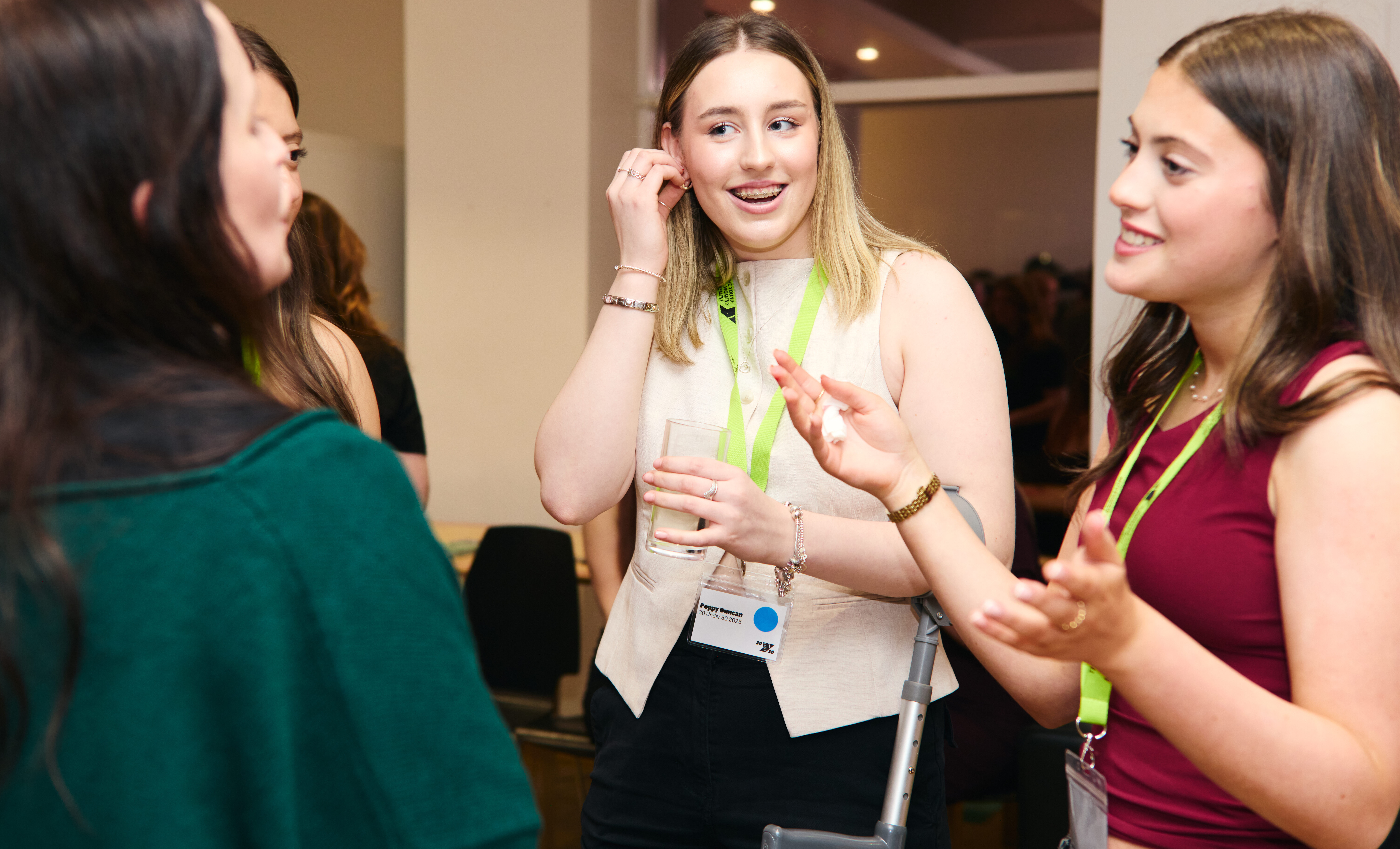 Three young women chatting at an event.