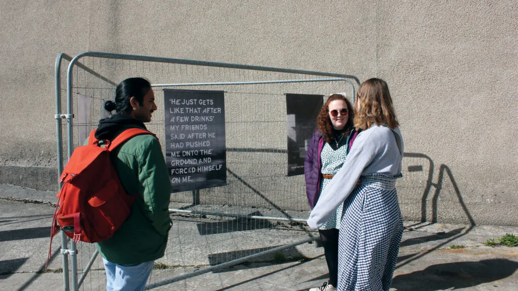 People standing in front of a poster. Poster reads: 