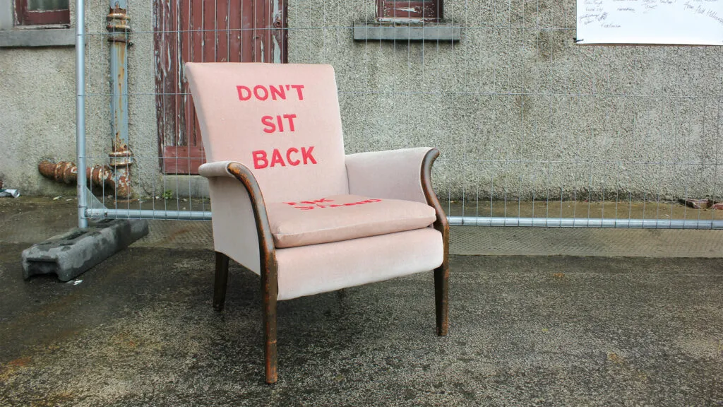 A pink arm chair with red paint, saying 