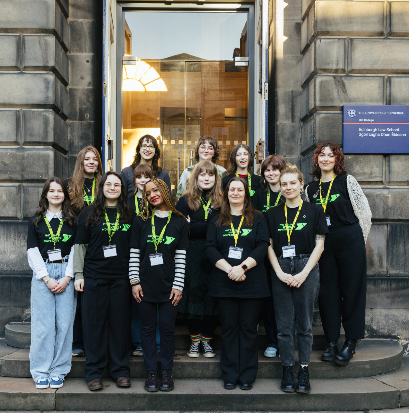 The Young Women Lead group are a diverse group of ten young women of different heights, skin tones and hair colour. They are all wearing green lanyards and smiling at the camera.