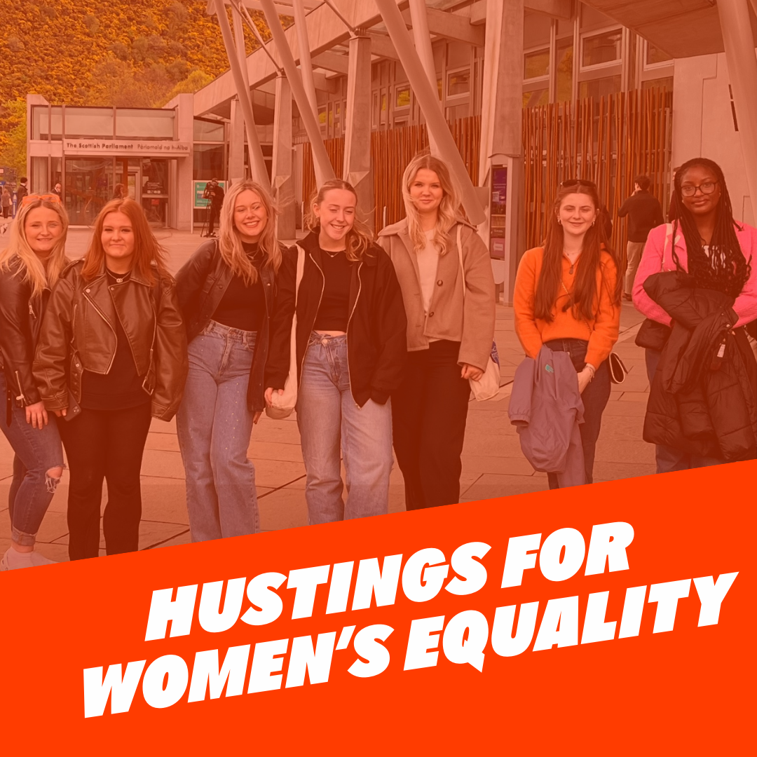 Women in front of parliament, with text that reads 'Hustings for women's equality'