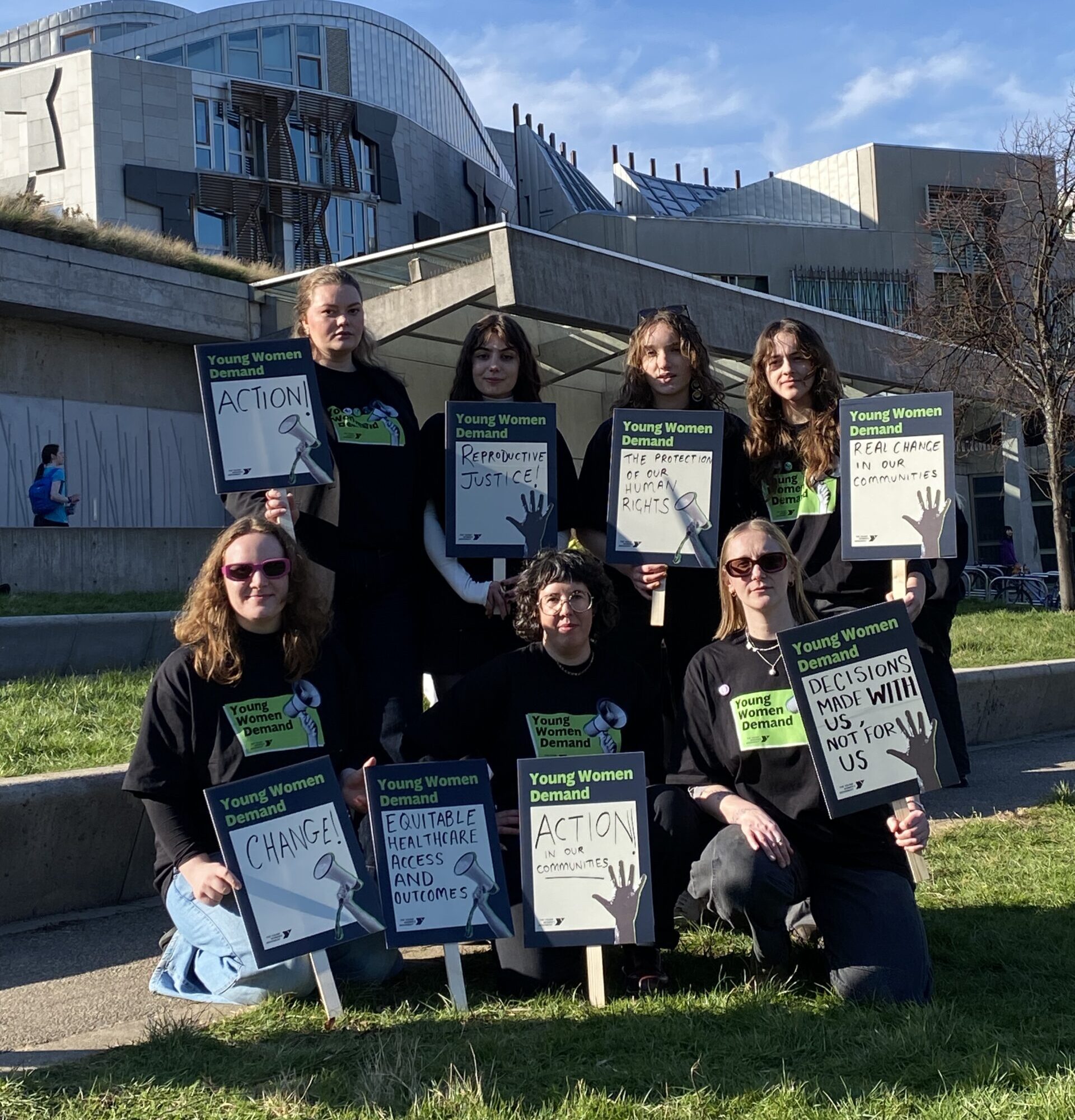 Our Young Women Demand group holding placards outside Holyrood