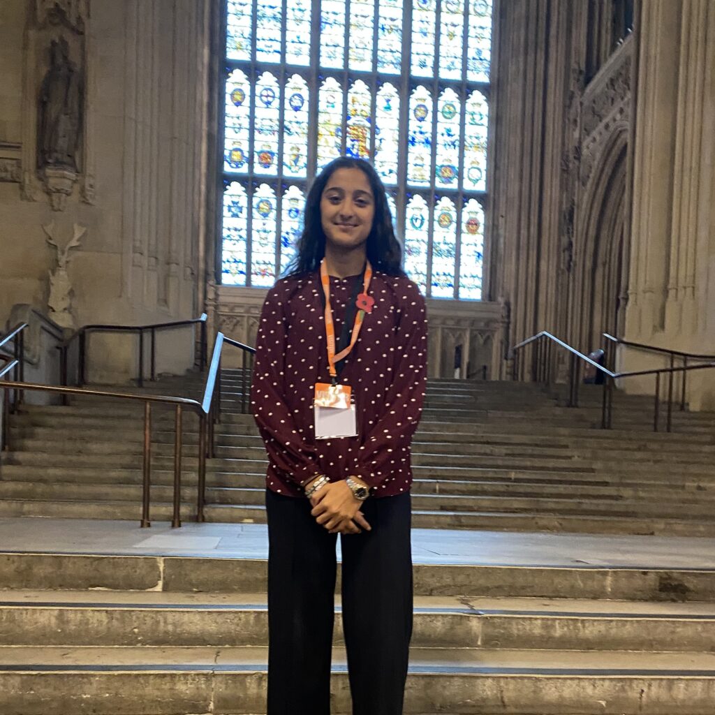 Rajsee is standing in a cathedral. She has brown skin and long dark hair.